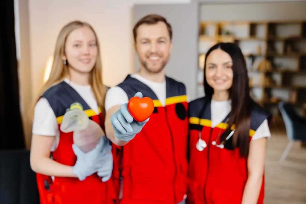 Un equipo médico, con un miembro sosteniendo un corazón, representa la exitosa selección de personal para el cuidado.