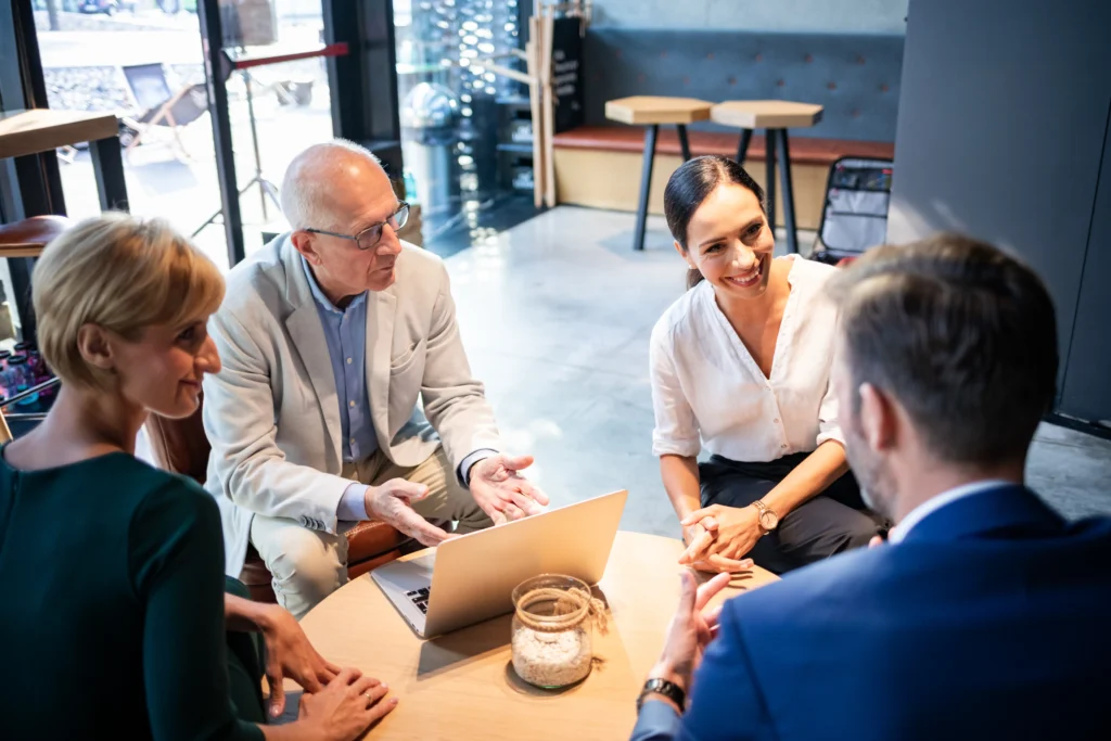 Cuatro profesionales discuten planes de crecimiento en un ambiente relajado, enfocados en la Institucionalización de empresas familiares.