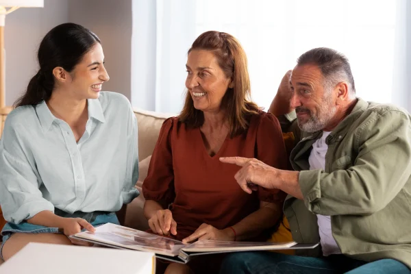 Grupo familiar conversando alegremente en la sala sobre ¿Qué decisiones puede y no puede tomar el consejo de familia? para mantener la armonía.