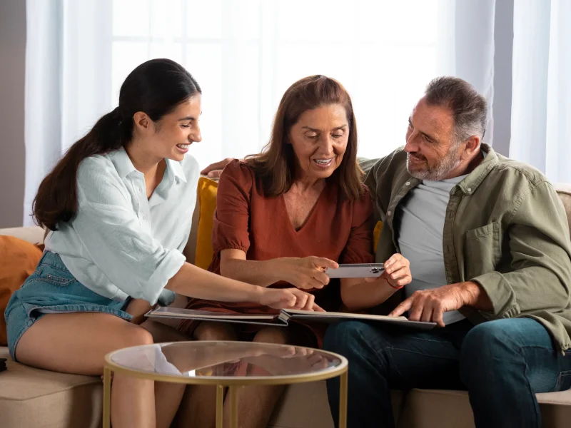 Grupo familiar conversando alegremente en la sala sobre ¿Qué decisiones puede y no puede tomar el consejo de familia? para mantener la armonía.