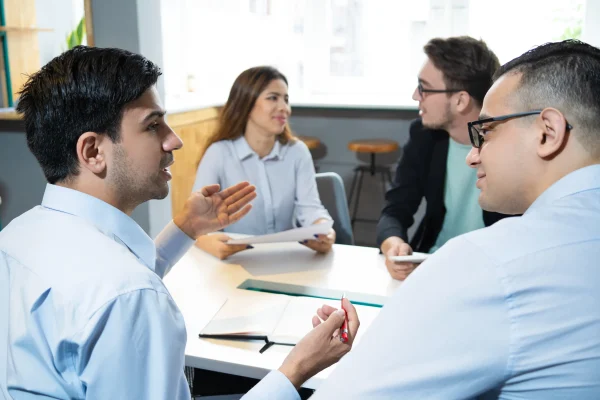 Equipo de consultores discutiendo la institucionalización de empresas en una oficina.